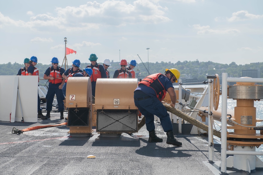 U.S. Coast Guardsmen attach tugboat to USCGC Calhoun