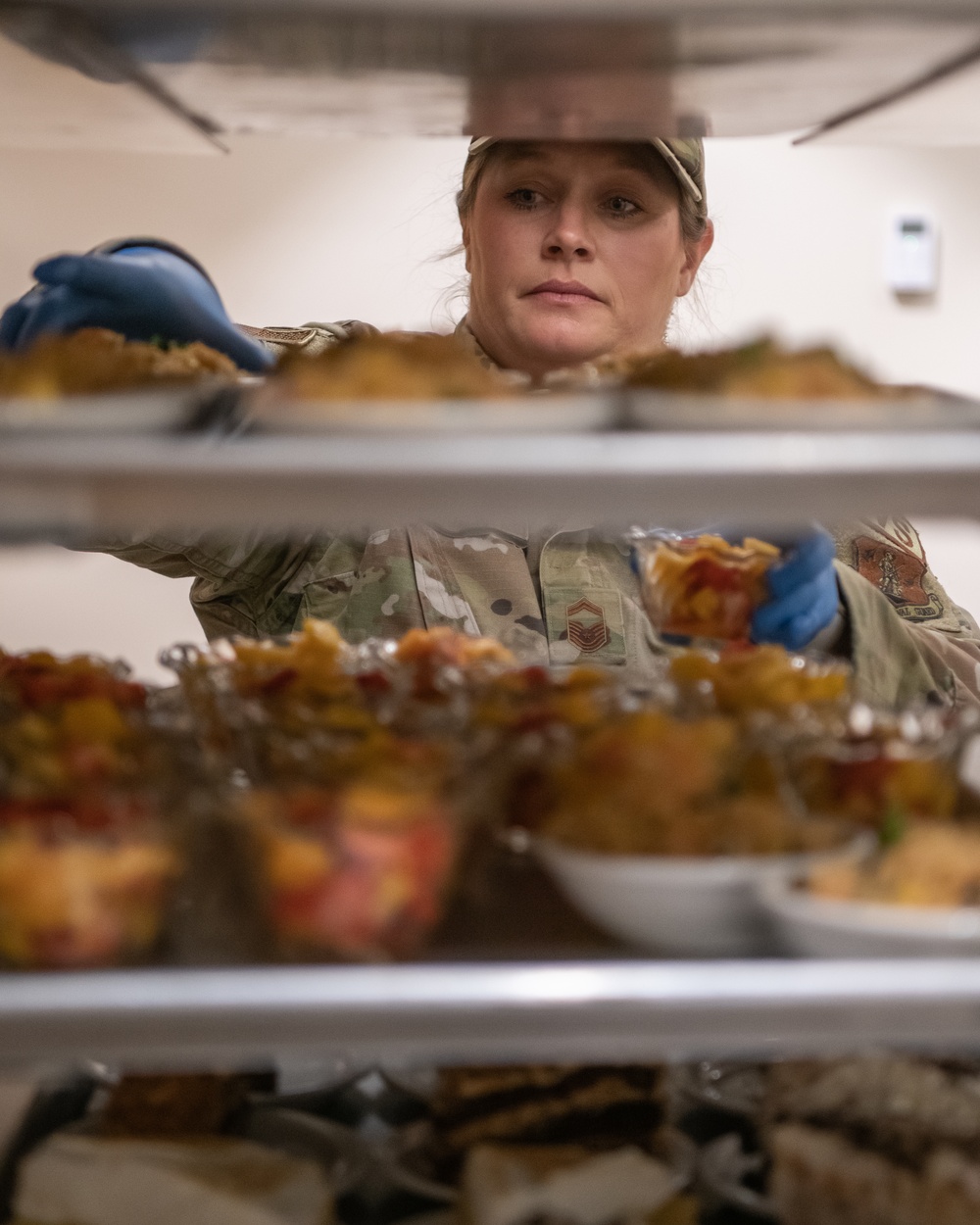 138th Fighter Wing services prepares a meal for the Air National Guard command chief