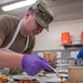 138th Fighter Wing services prepares a meal for the Air National Guard command chief