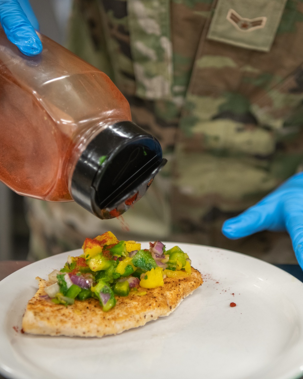 138th Fighter Wing services prepares a meal for the Air National Guard command chief