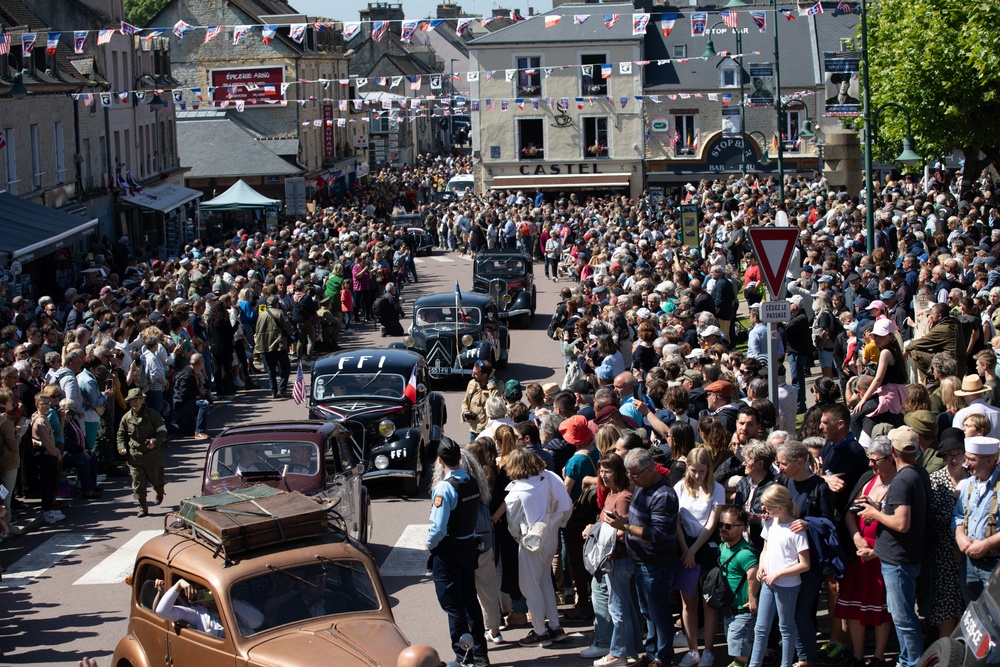 French and American citizens observe a parade through the town square