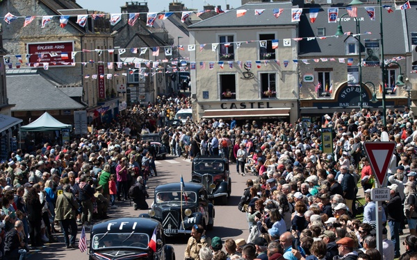 French and American citizens observe a parade through the town square