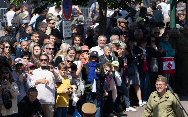 French and American citizens observe a parade through the town square
