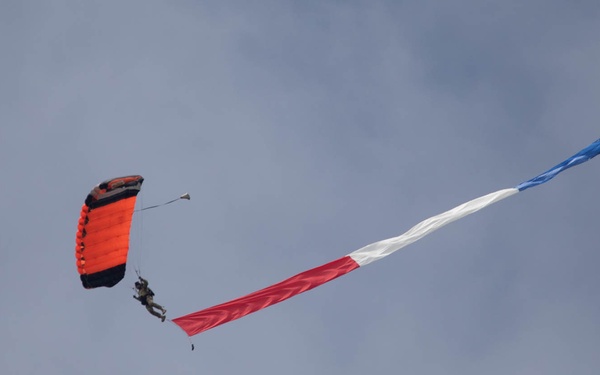 Service members perform a free-fall jump near Amfreville, France
