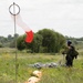Service members and civilians perform a freefall jump near Amfreville, France