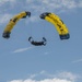Service members and civilians perform a free-fall jump near Amfreville, France