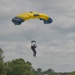 Service members and civilians perform a freefall jump near Amfreville, France