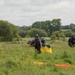Service members and civilians perform a freefall jump near Amfreville, France