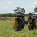 Service members and civilians perform a freefall jump near Amfreville, France
