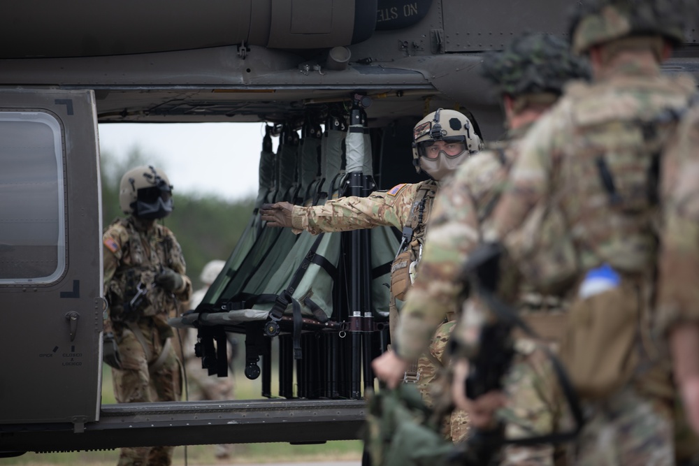 U.S. Army Sgt. Timothy Cassinera and Sgt. Dillon Johnson of Alpha Company, 2-285th Assault Helicopter Battalion and Bravo Company 2-285th Aviation Regiment, instructs Soldiers in and out of a Black Hawk helicopter