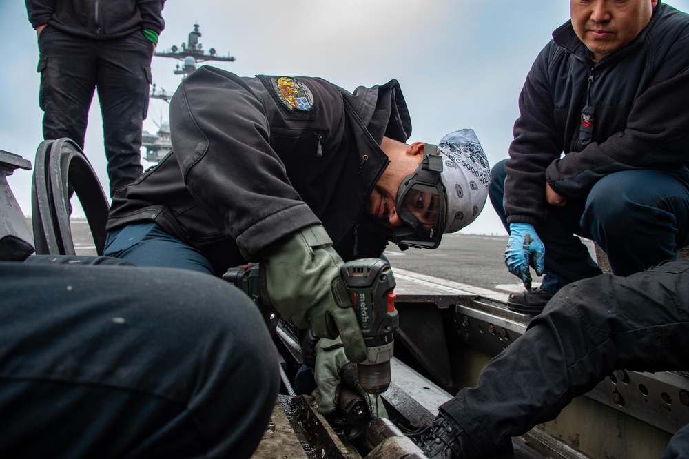 USS Carl Vinson (CVN 70) Sailor Conducts Preventative Maintenance On An Aircraft Catapult