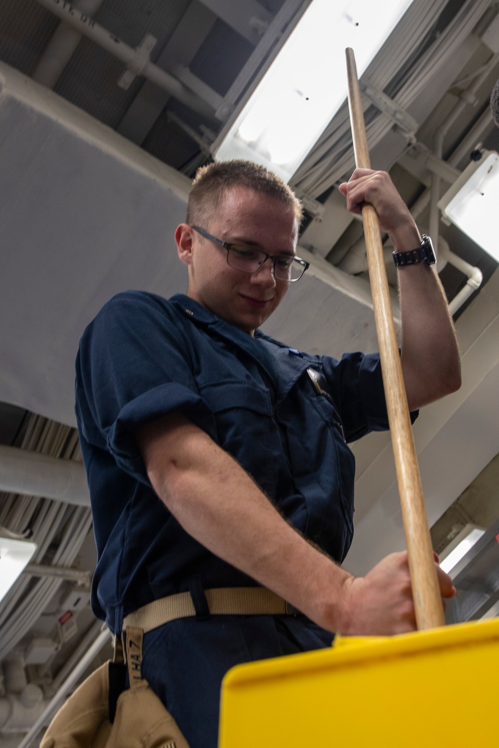 Midshipmen clean the mess decks aboard USS Tripoli