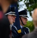 Airman looks on as Brig. Gen. Tomika Seaberry delivers speech during DDay 80