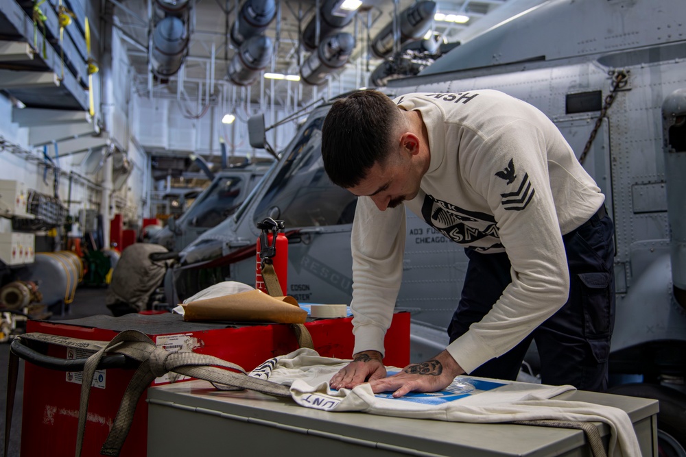 Sailor stencils jersey aboard Abraham Lincoln