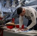 Sailor stencils jersey aboard Abraham Lincoln