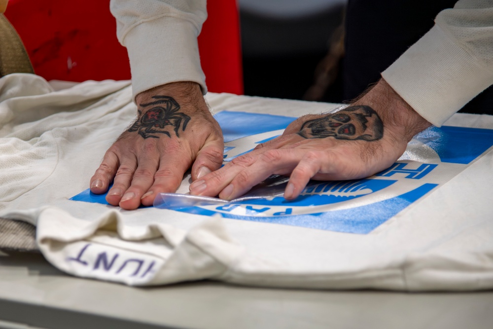 Sailor stencils jersey aboard Abraham Lincoln