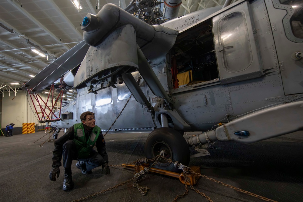 Sailor prepares to transport helicopter aboard Abraham Lincoln