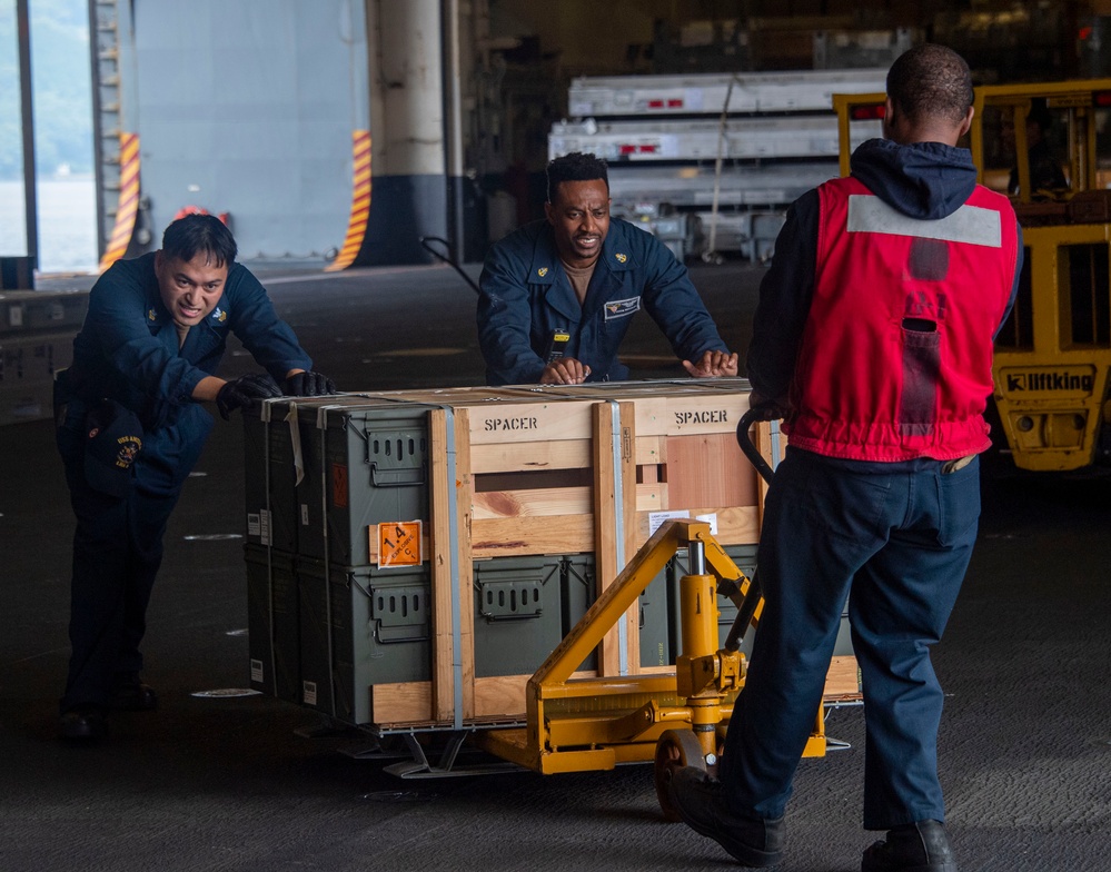 Sailors assigned to the USS America (LHA 6) particpates in a ordnance handling evolution