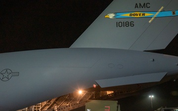 U.S. military personnel work side by side to oversee the loading of equipment onto a U.S. Air Force C-17 Globemaster III aircraft