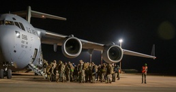 U.S. service members bid farewell to their teammates as they board the U.S. Air Force C-17 Globemaster III aircraft