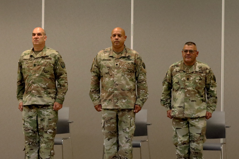 CSM Natal receives the ceremonial blade from LTC Rodriguez and CSM Gonzalez, signifying his new role as the Command Sergeant Major of the Caribbean Readiness Group during the Change of Responsibility Ceremony at Fort Buchanan, Puerto Rico.