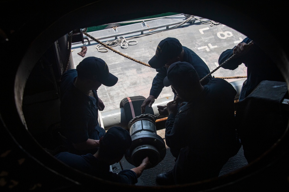 Sailors assigned to the USS America (LHA 6) handle a fueling hose