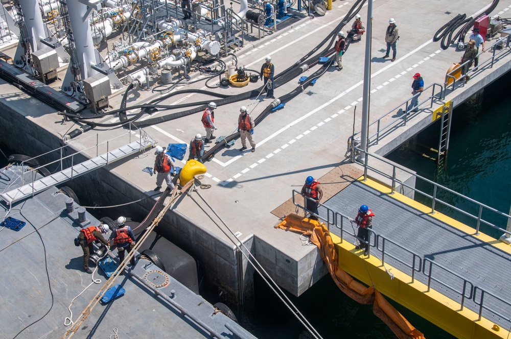 Defense Fuel Supply Point personnel handle a fueling hose for the USS America (LHA 6)
