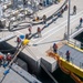 Defense Fuel Supply Point personnel handle a fueling hose for the USS America (LHA 6)