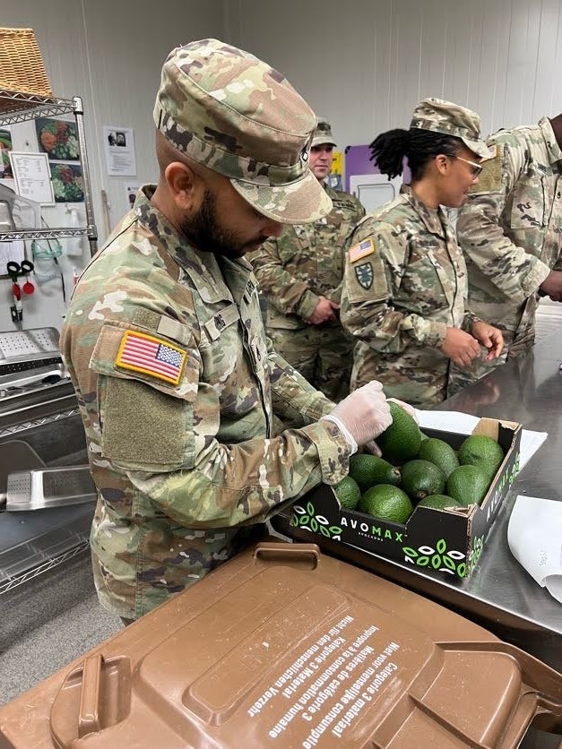 Staff Sgt. Castonia Ming inspecting avocados as part of a food inspection at a dining facility.