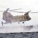 A competitor in the 2024 U.S. Army Special Operations Command (USASOC) Best Combat Diver Team Competition jumps off the tailgate of an CH-47