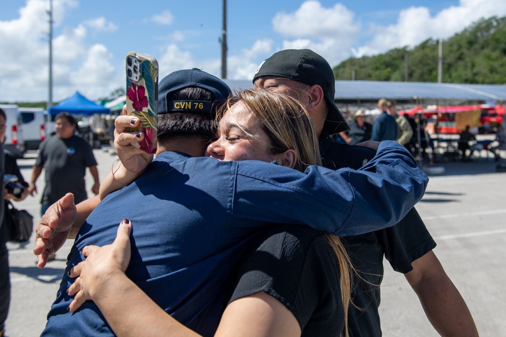 USS Ronald Reagan (CVN 76) Sailors greet family on the pier after arriving at Naval Base Guam for scheduled port visit