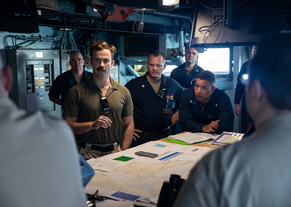 ESL Sailors and Military Sealift Command civil service mariners discuss navigation operations on the bridge