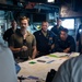 ESL Sailors and Military Sealift Command civil service mariners discuss navigation operations on the bridge