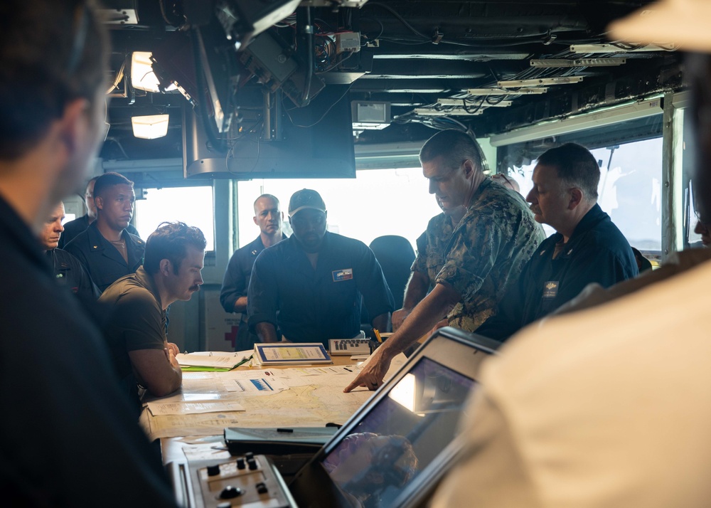 ESL Sailors and Military Sealift Command civil service mariners discuss navigation operations on the bridge