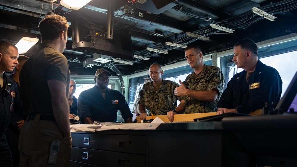 ESL Sailors and Military Sealift Command civil service mariners discuss navigation operations on the bridge