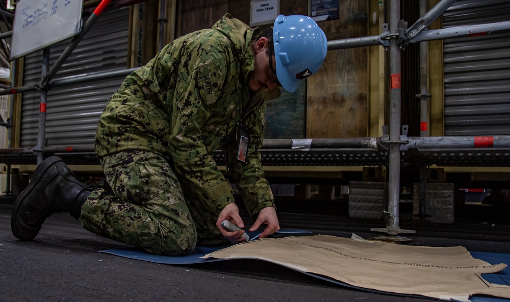 United States Navy Sailor Cuts Electrical Matting Into Shape