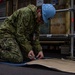 United States Navy Sailor Cuts Electrical Matting Into Shape