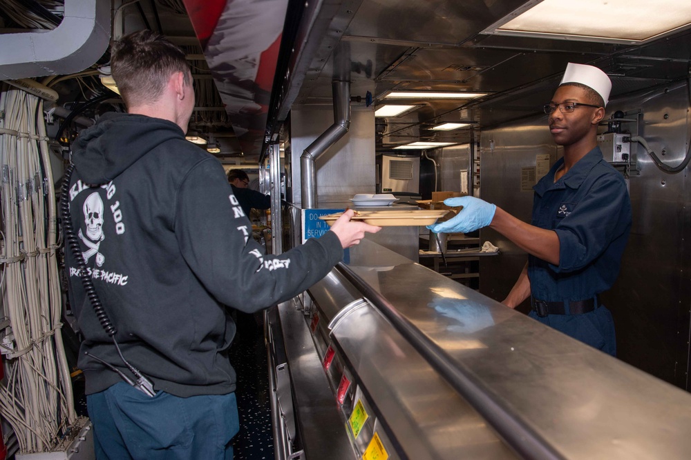 USS Kidd (DDG-100) Sailor Serves Food