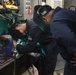 Sailors aboard the USS Howard conduct maintenance on a guard rail in the Pacific Ocean