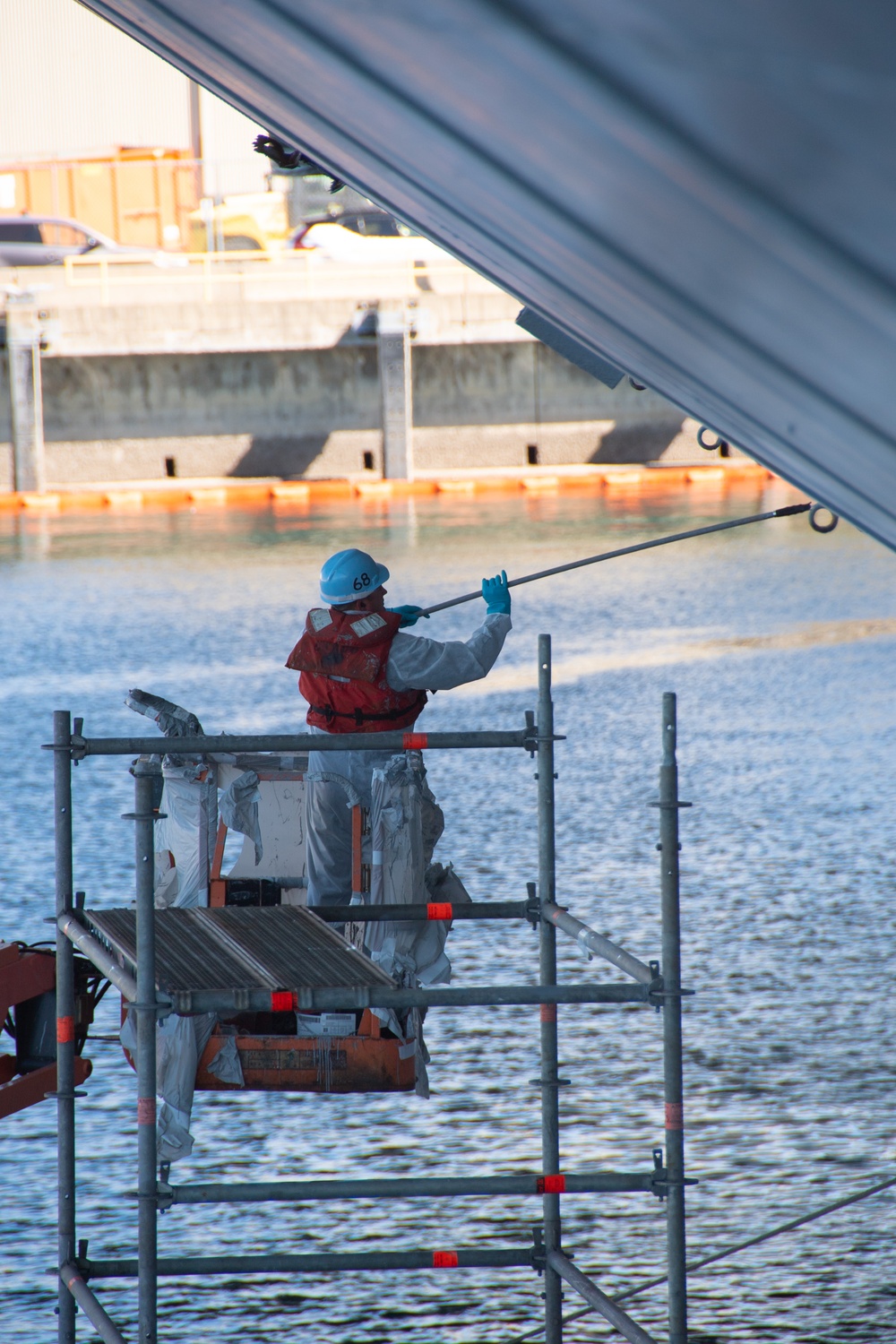 Sailor Paints Hull of Ship