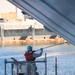 Sailor Paints Hull of Ship