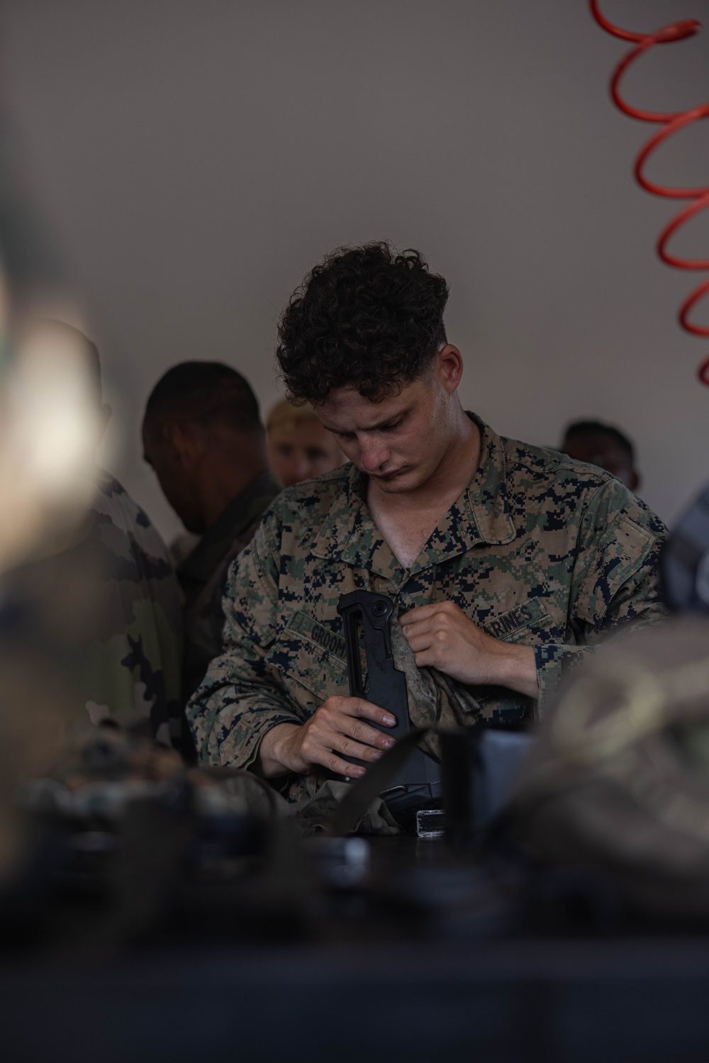 U.S. Marines, French soldiers clean FAMAS rifles during Marara 24