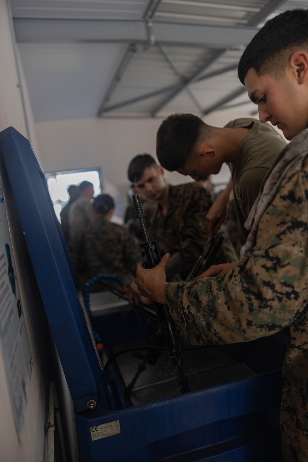 U.S. Marines, French soldiers clean FAMAS rifles during Marara 24