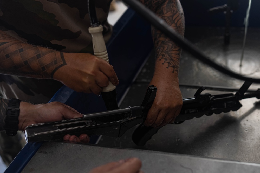 U.S. Marines, French soldiers clean FAMAS rifles during Marara 24