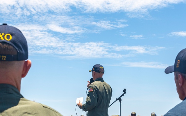 Abraham Lincoln conducts an all-hands call on the flight deck