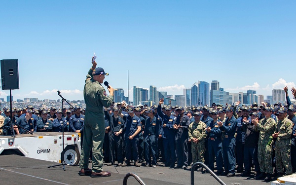 Abraham Lincoln conducts an all-hands call on the flight deck