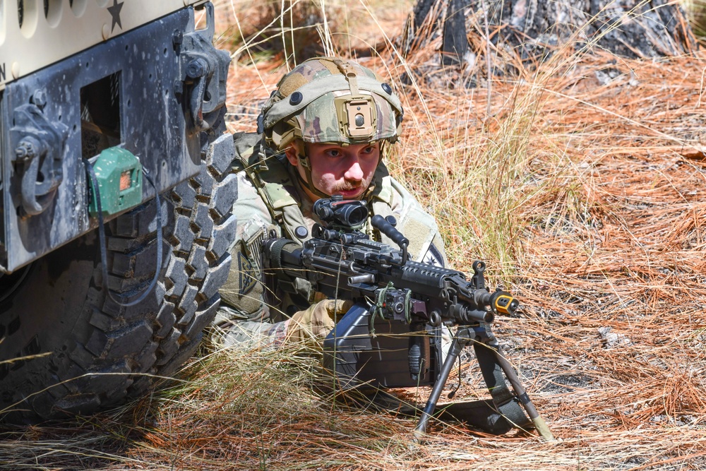 Combat medics use the M249 light machine gun during a field observational assessment