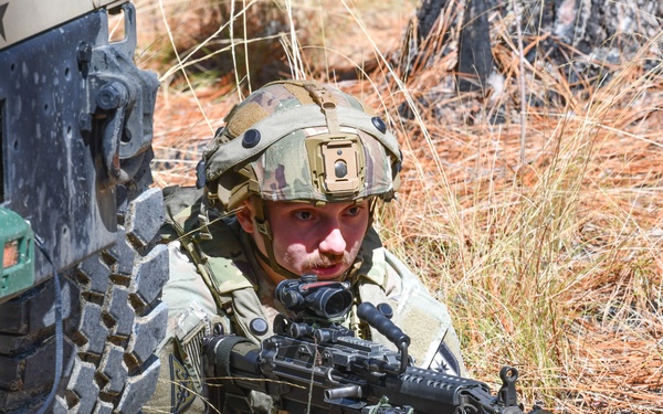 Combat medics use the M249 light machine gun during a field observational assessment