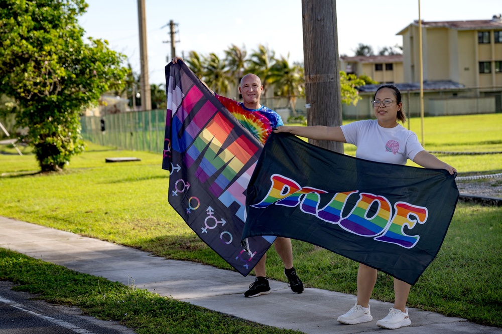 Staff and Sailors Hold Flags During a Pride Event on Camp Covington