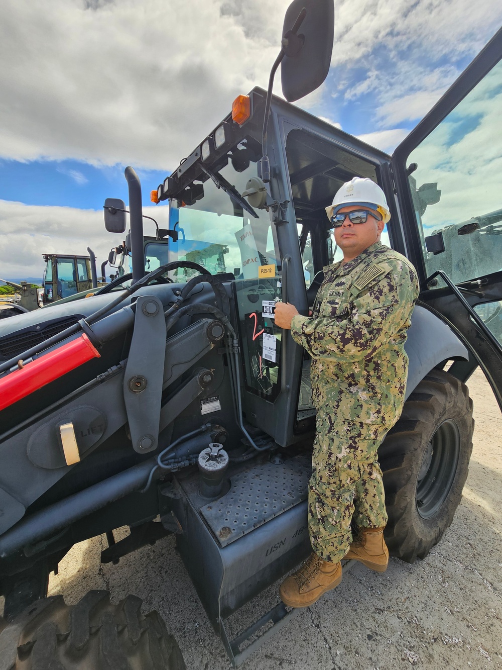 EOC Earley stands with his excavator at Joint Base Pearl Harbor-Hickam during RIMPAC 2024